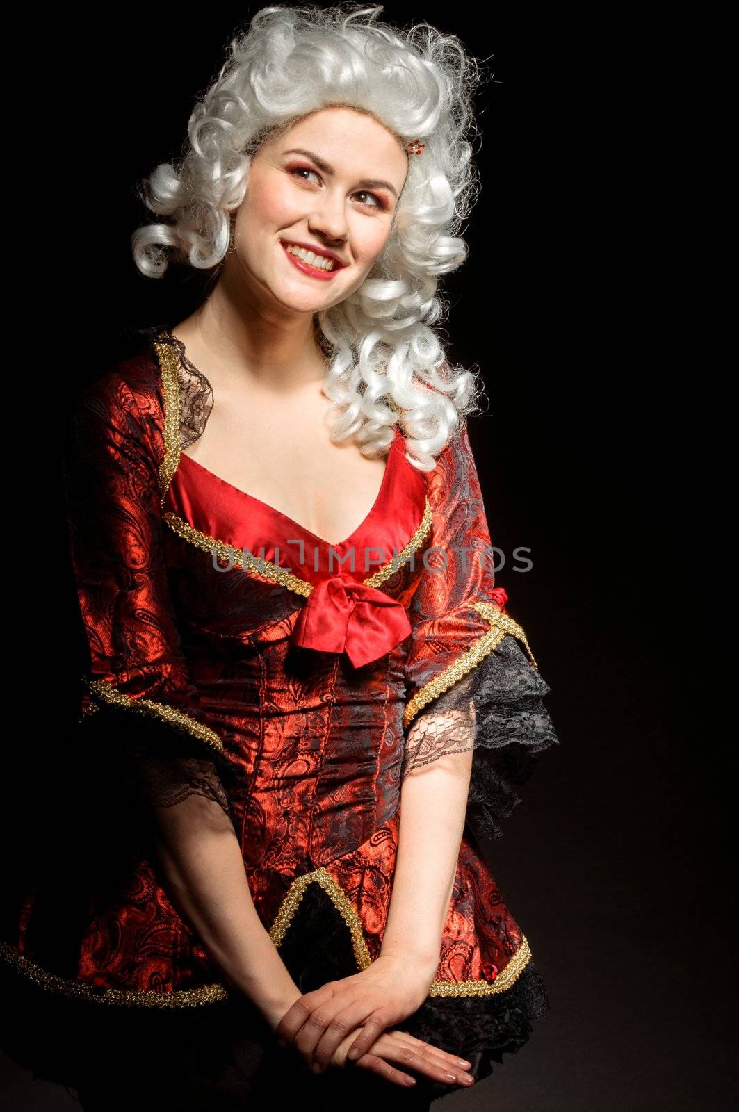 Young woman in baroque costume against dark background