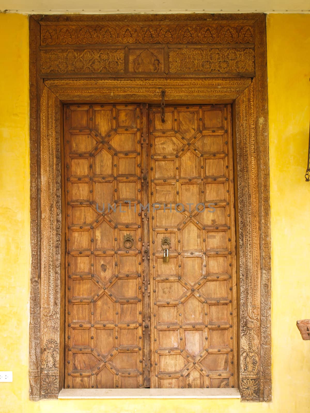 Antique Moroccan style wooden door on yellow wall