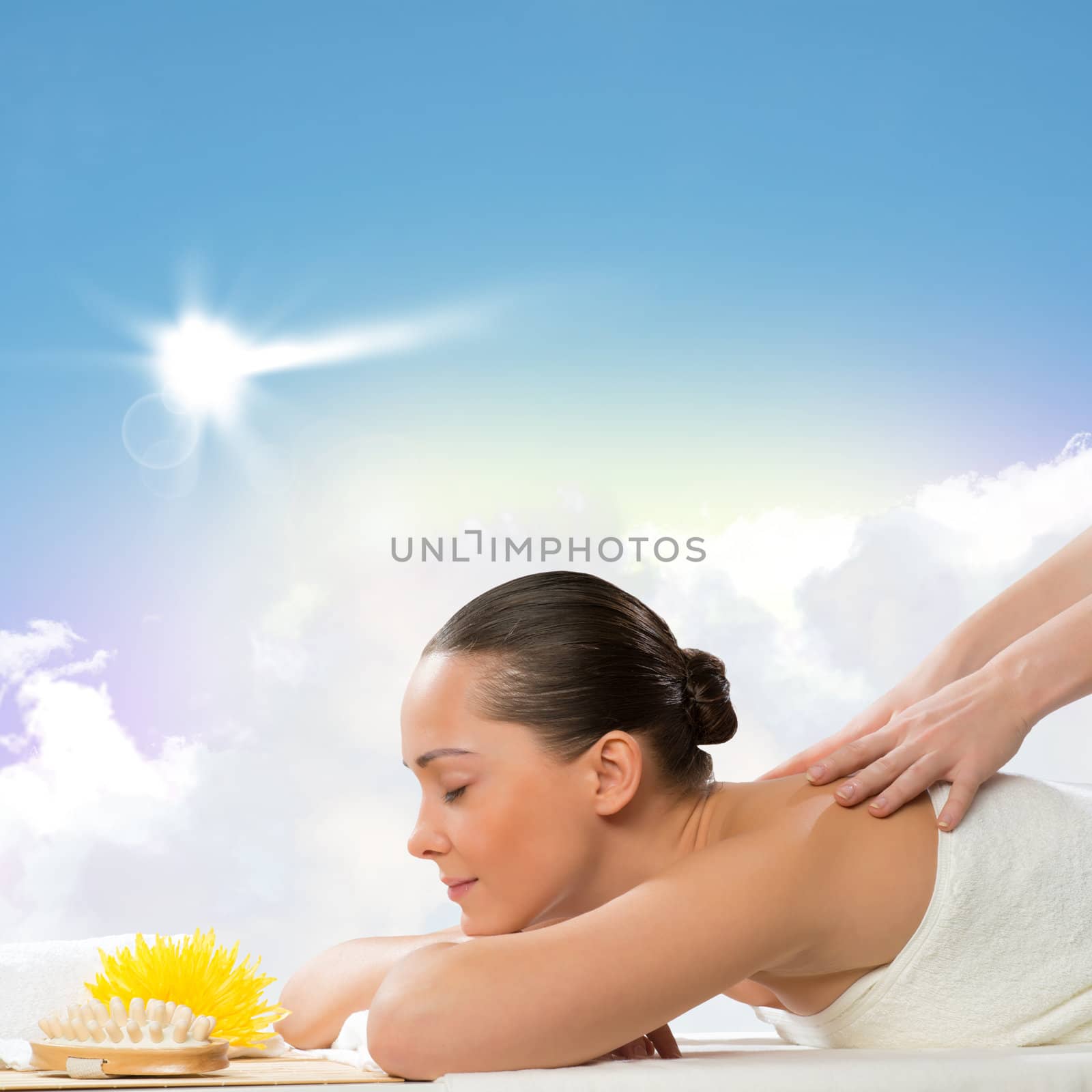 beautiful spa woman lying on the couch, in front of her flower and rolled towel