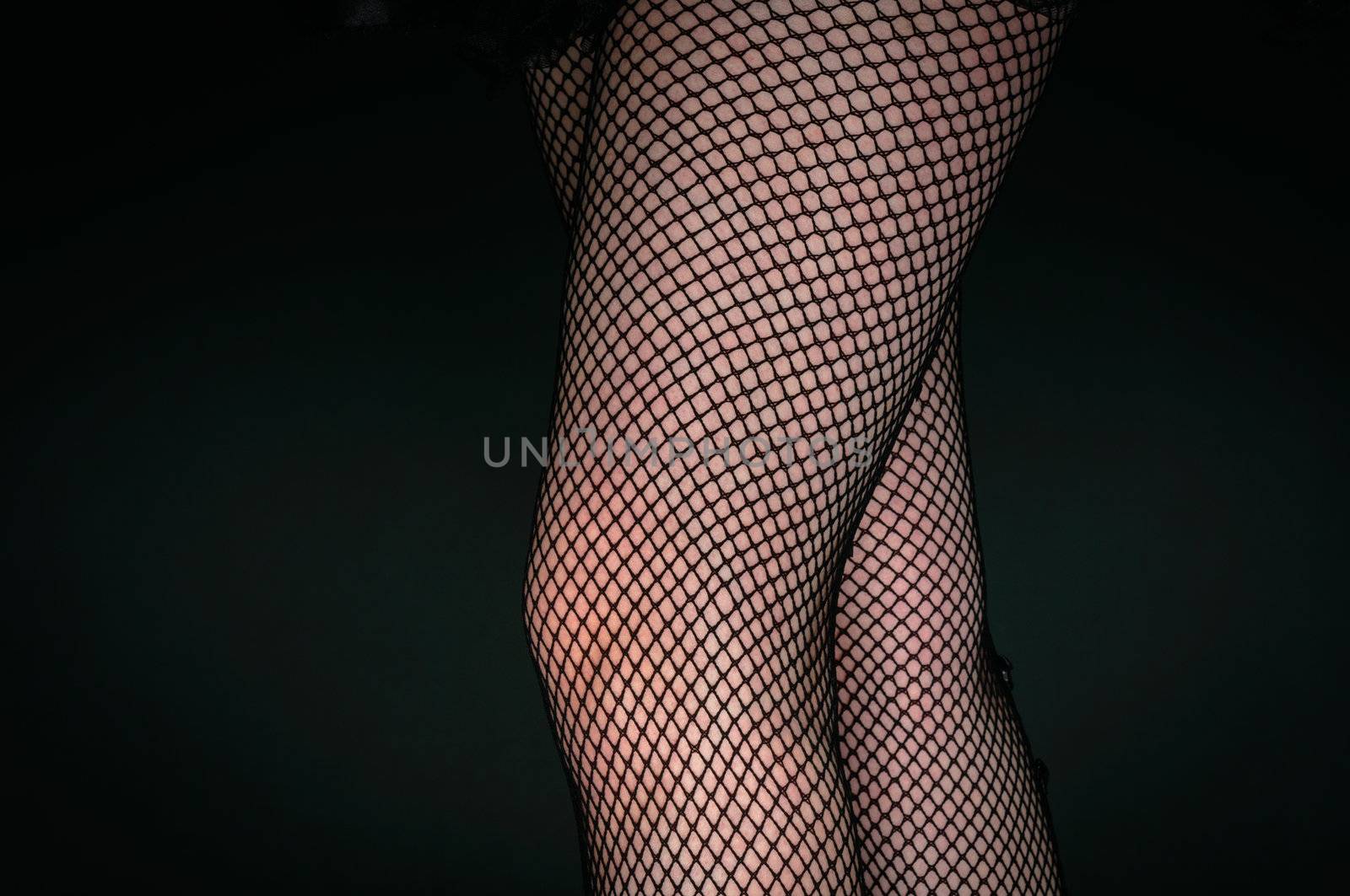 Legs of a youn woman against dark background closeup