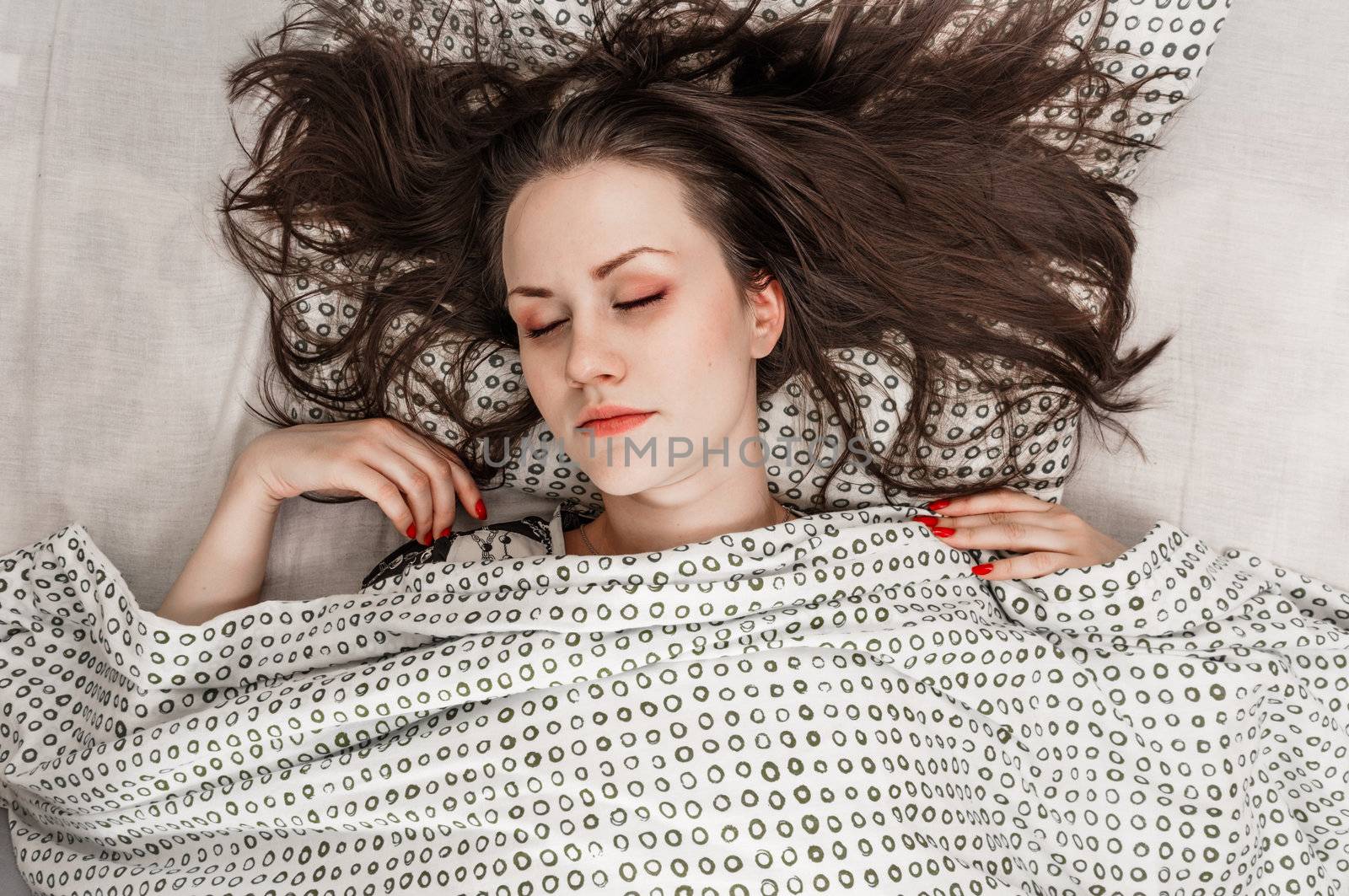 Young woman in the bed in bright light