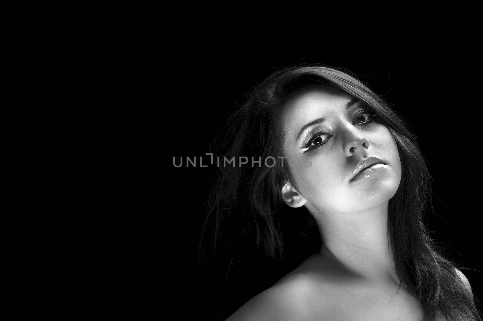 Girl with long hair in the studio against dark background