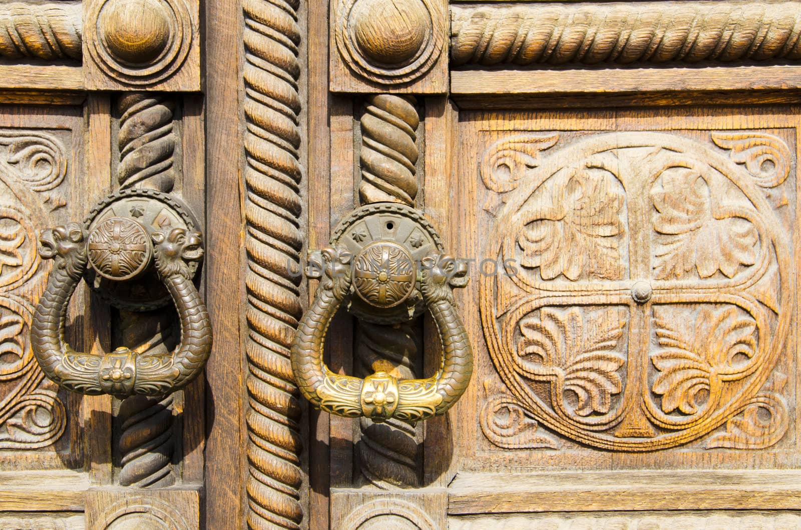 Two old handles on a wooden door with ornaments by velislava