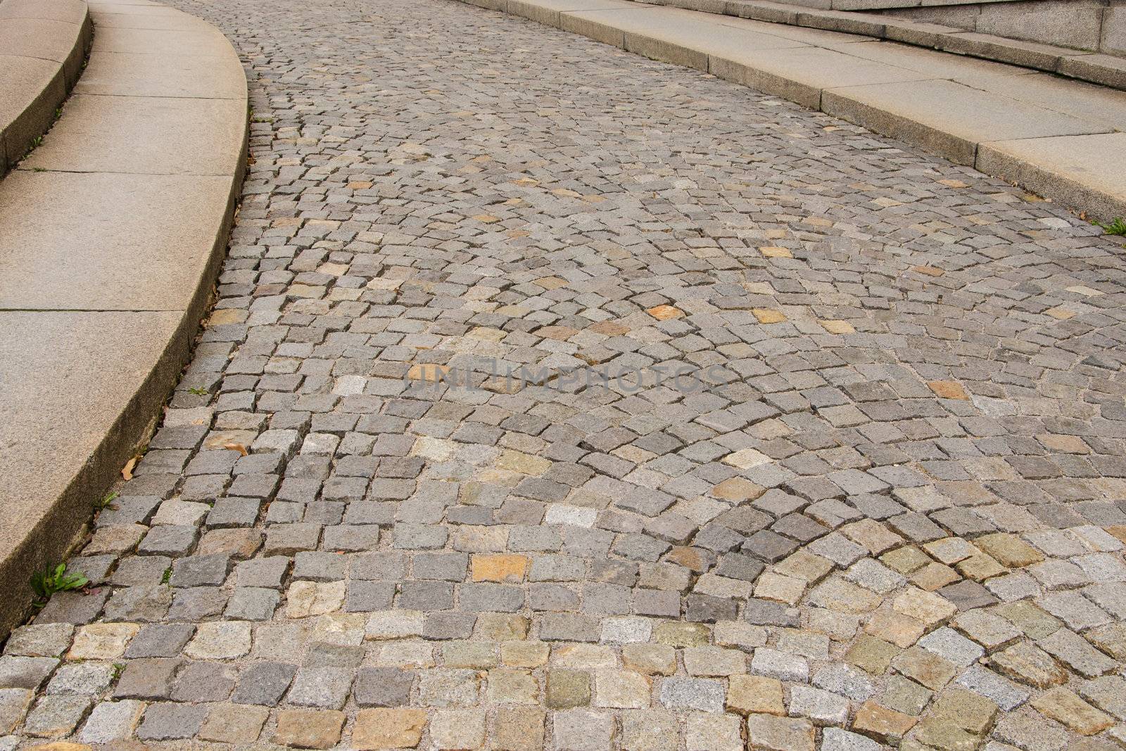 A paved street with a curb under intense uphill