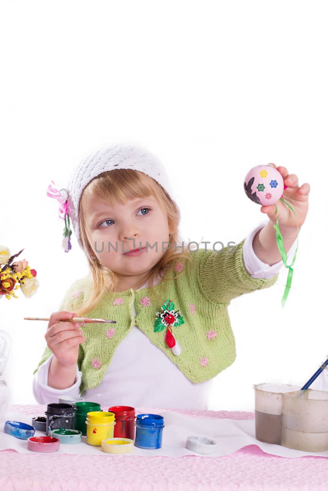 Little girl decorating easter eggs over white