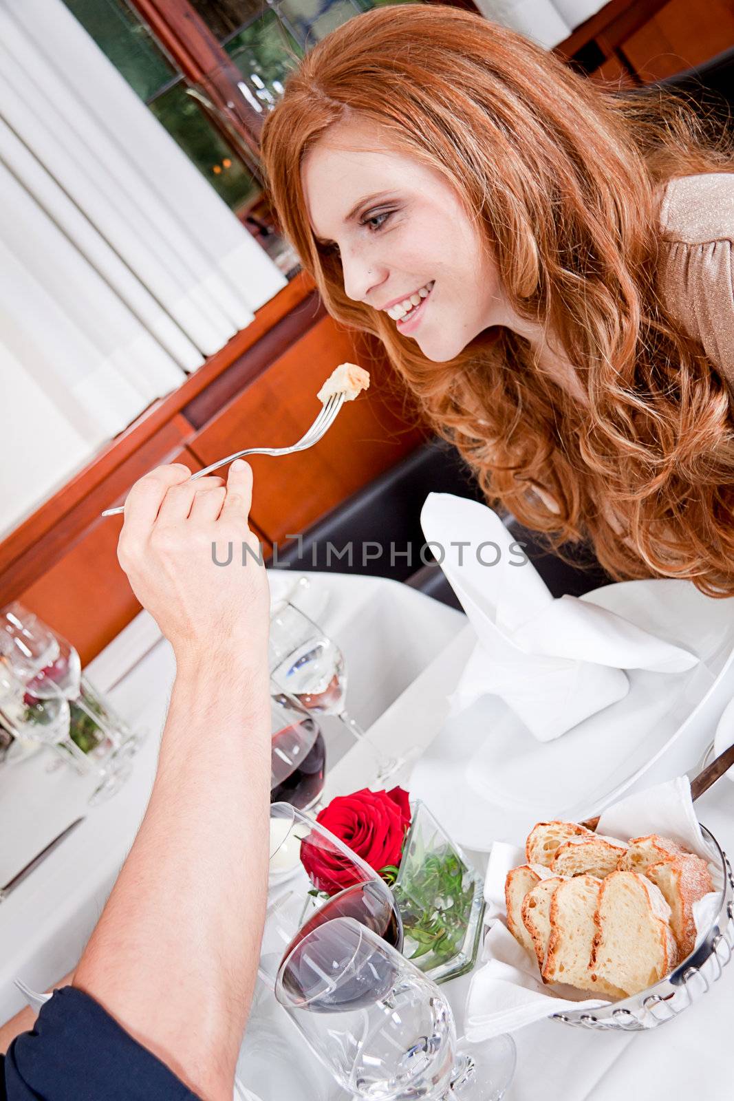 happy couple in restaurant or dinner eating and drinking wine smilig 