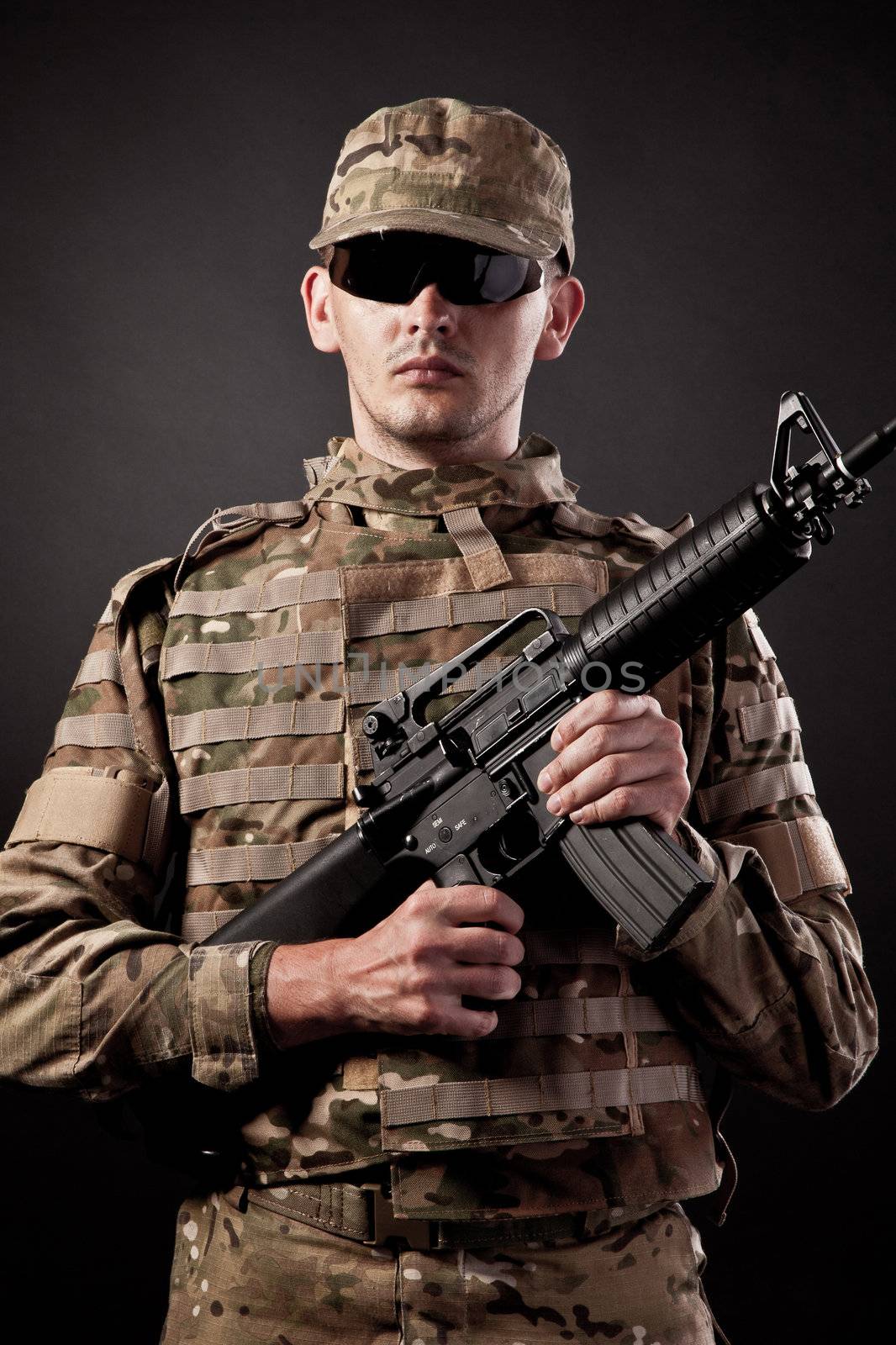 Modern soldier with rifle isolated on a black background