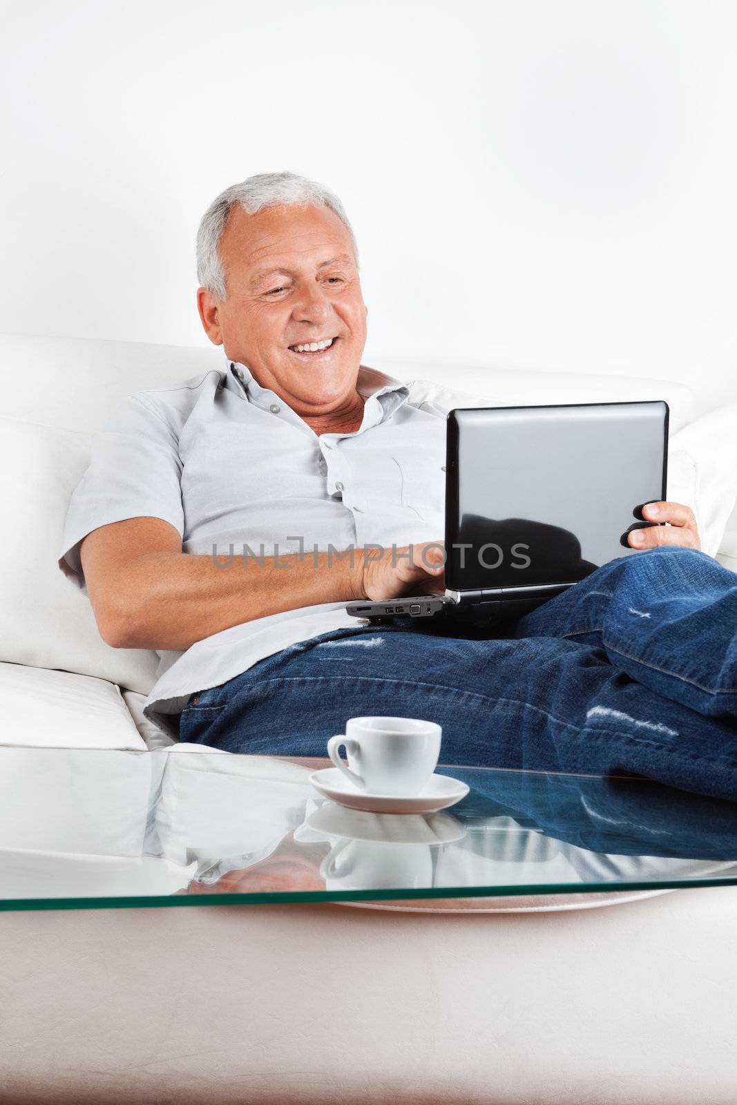 Relaxed Senior Man Working on Laptop by leaf