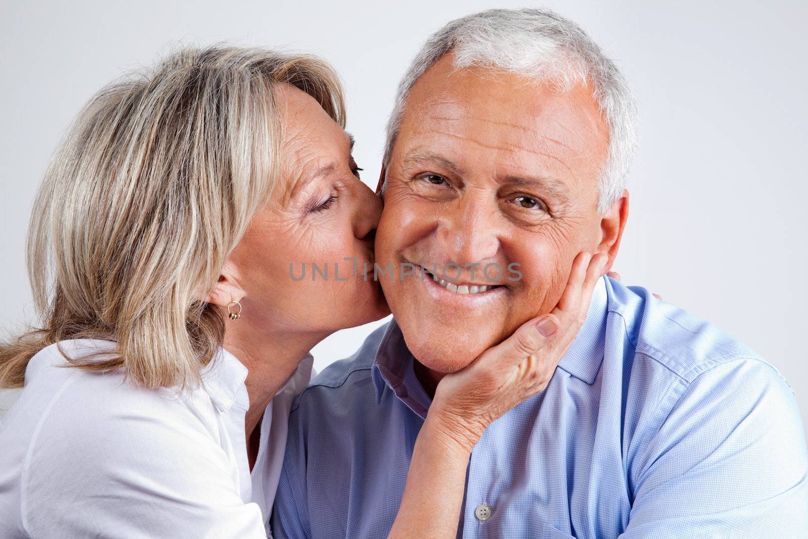 Senior Man Being Kissed By His Wife by leaf