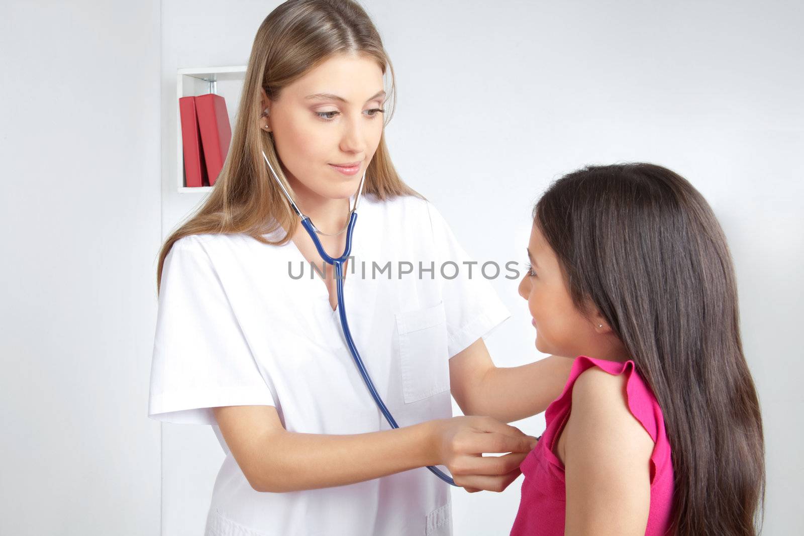 Female doctor examining child patient in clinic.