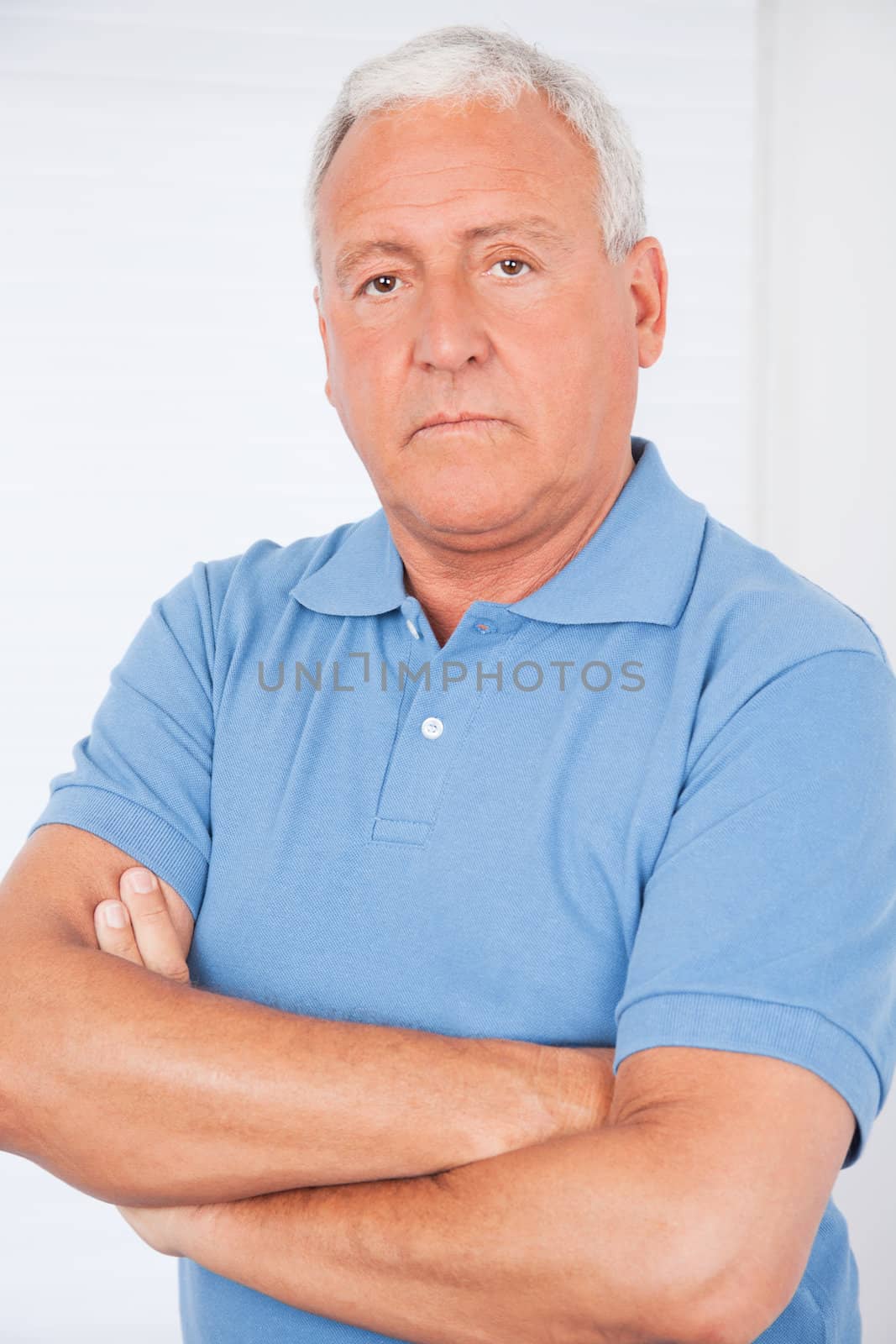 Portrait of serious senior man with arms crossed