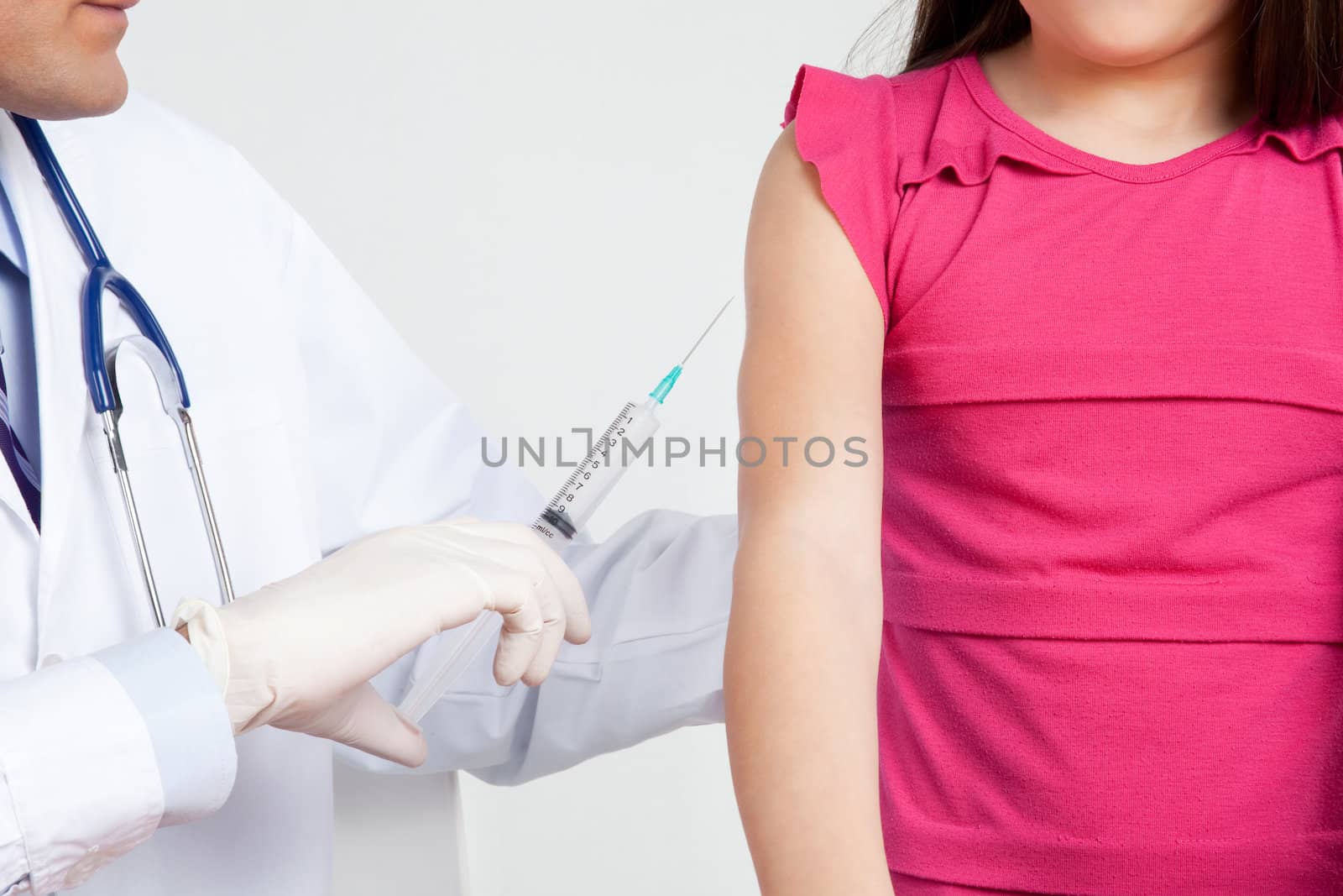 Doctor giving child patient injection in clinic.