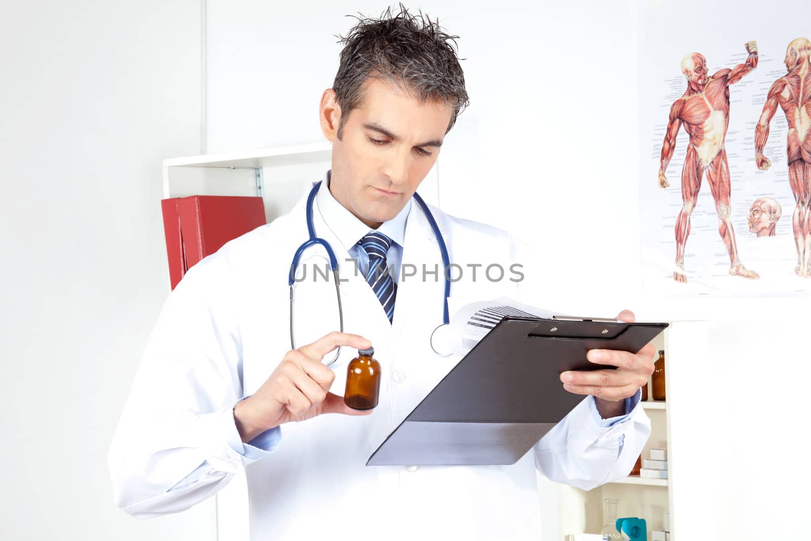 Doctor looking at clipboard holding a bottle.