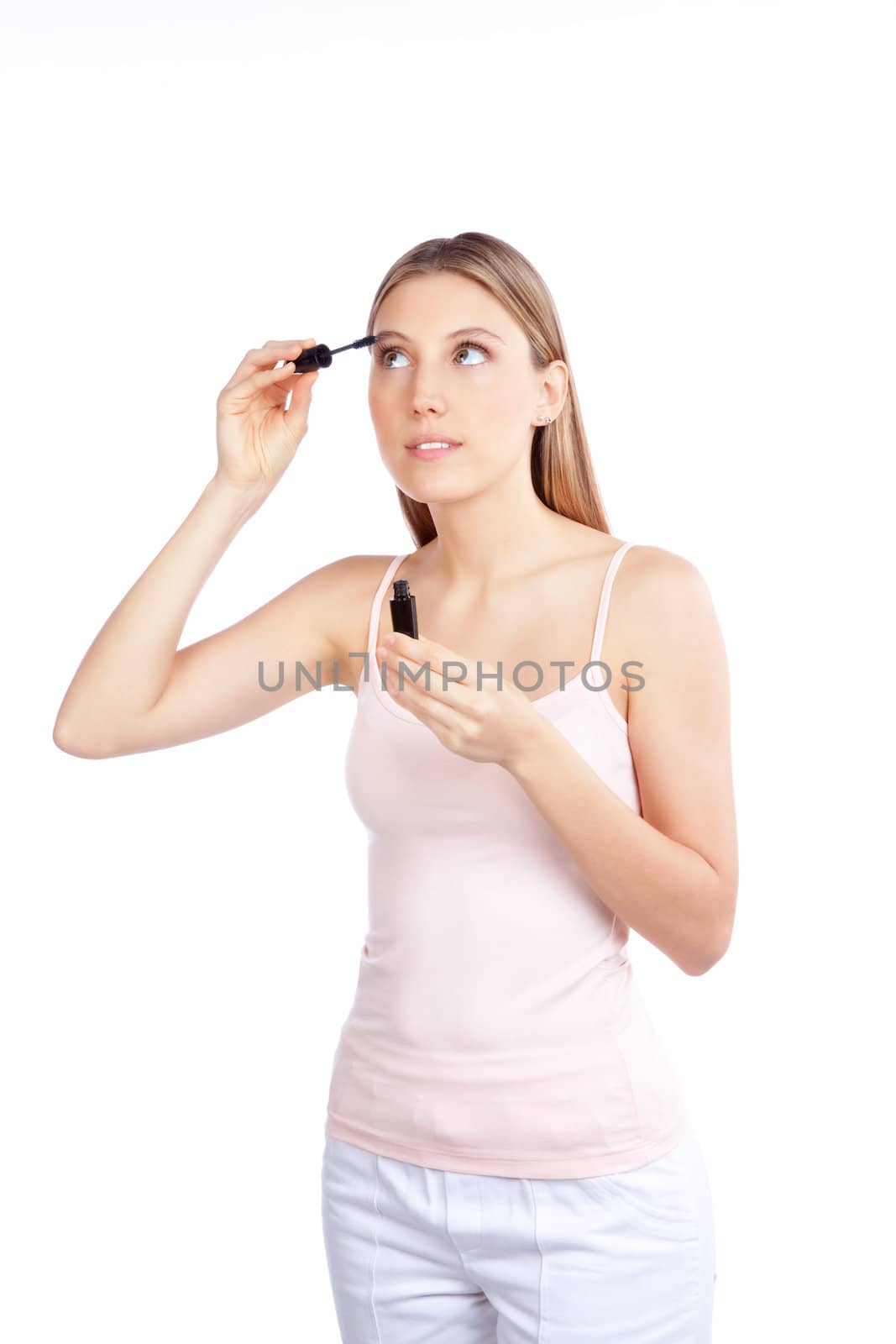 Beautiful woman applying mascara on her eyelashes.