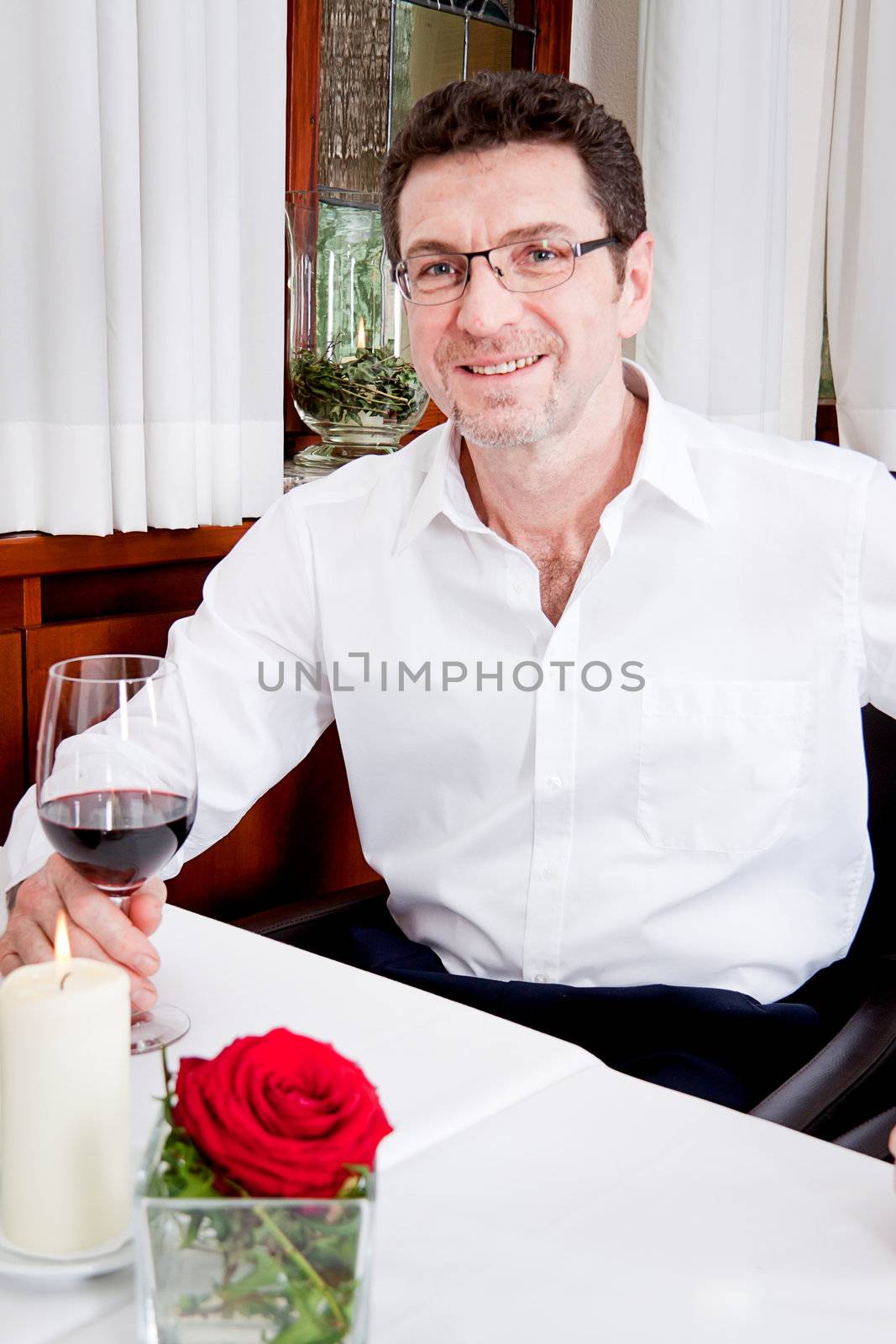 man and woman in restaurant for dinner drinking red wine and smiling