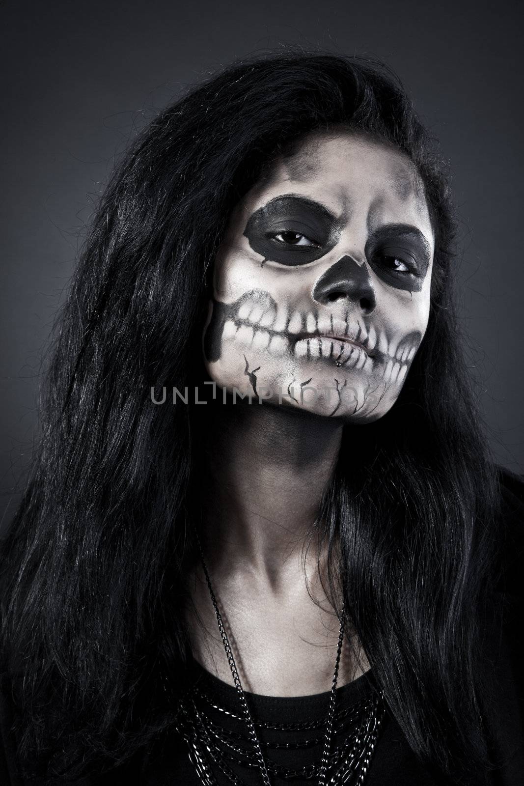 Young woman in day of the dead mask skull. Halloween face art by bloodua
