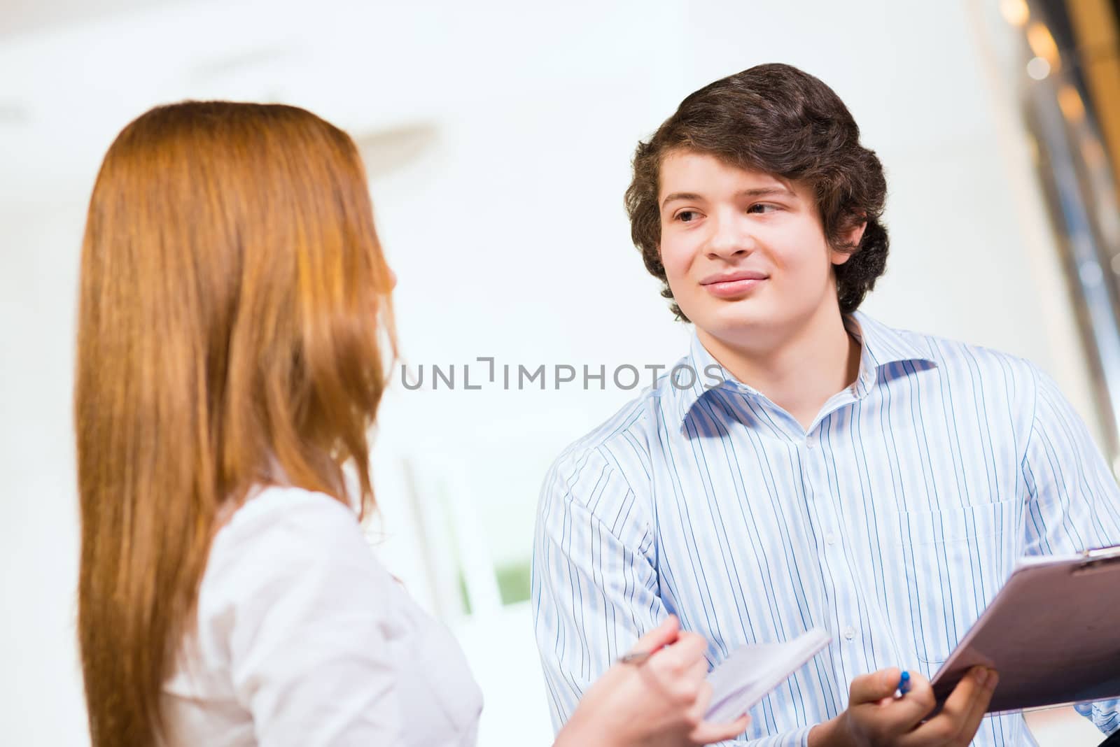 Attractive young man and woman sitting on the floor talking