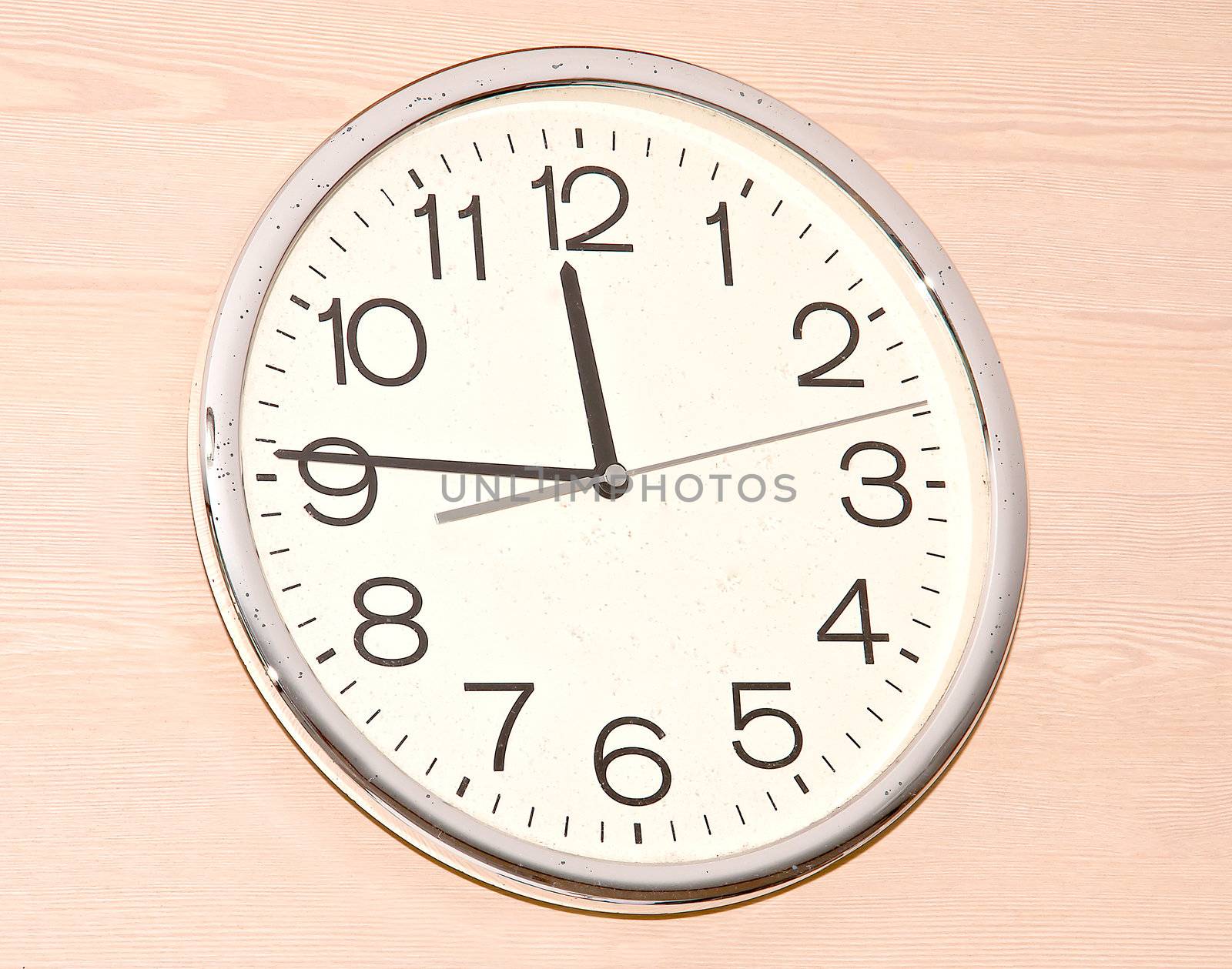 White clock hanging on a wooden wall brown.