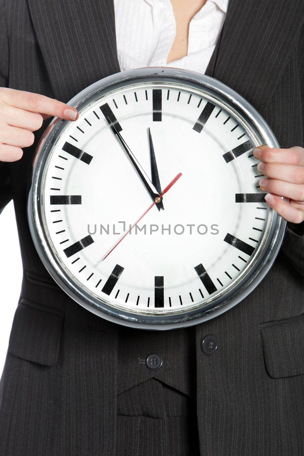 Cropped view of the hands of a woman holding a clock showing a time of five to twelve