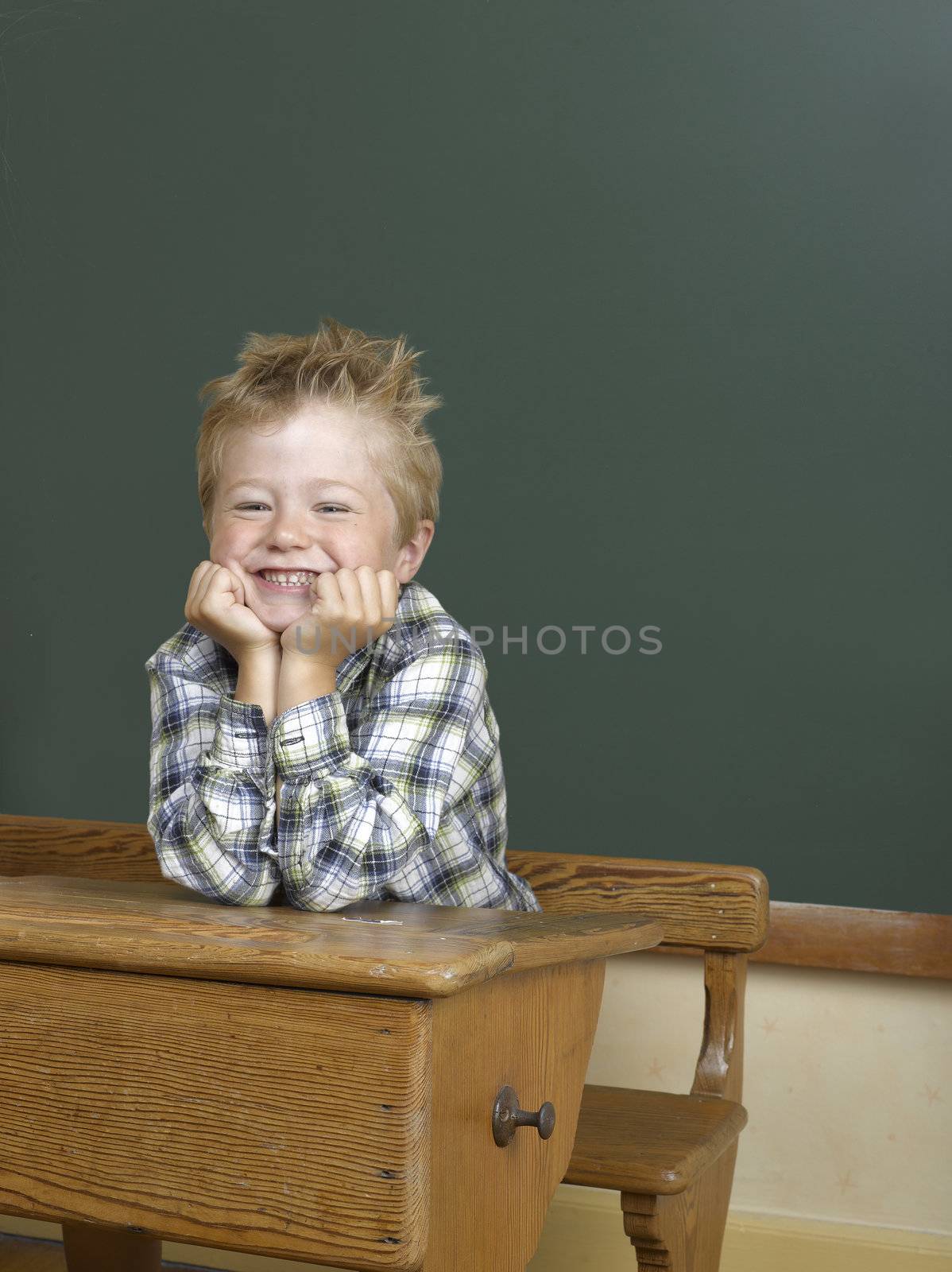 boy on a school desk in front of a background picture