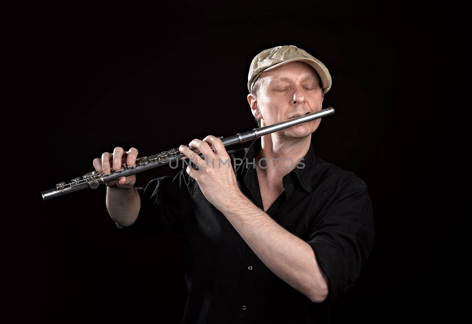 Portrait of a man playing old silver transverse flute by pbombaert