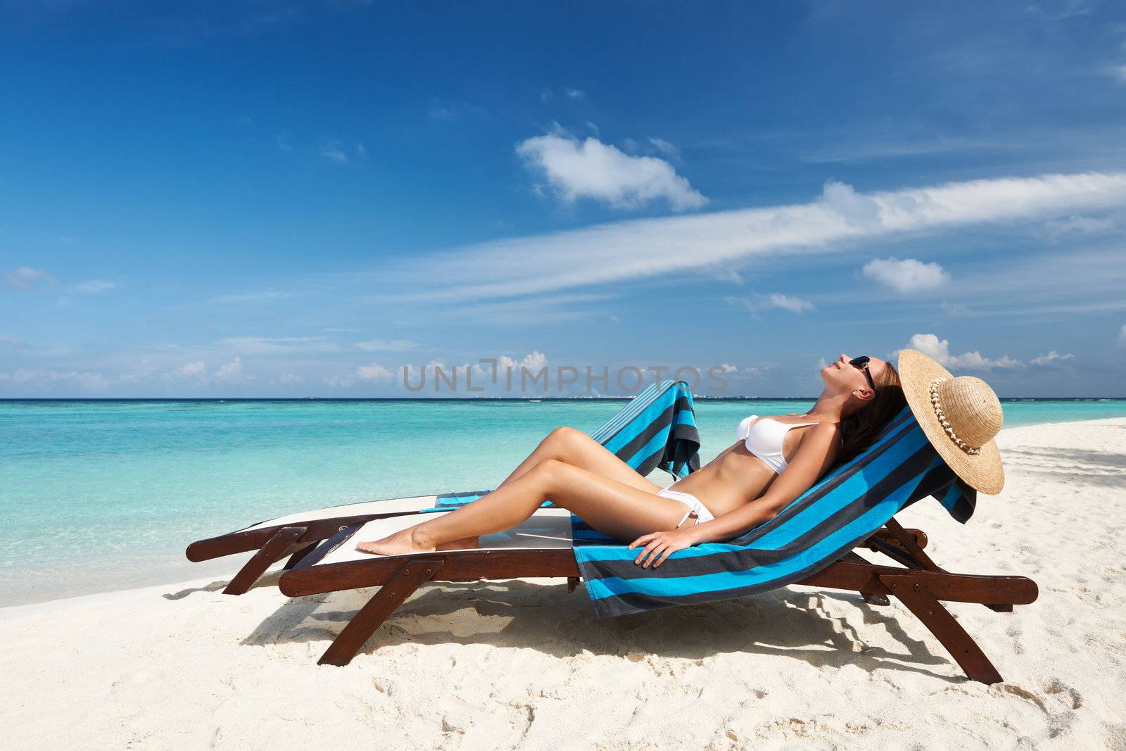 Young woman in chaise lounge at the beach