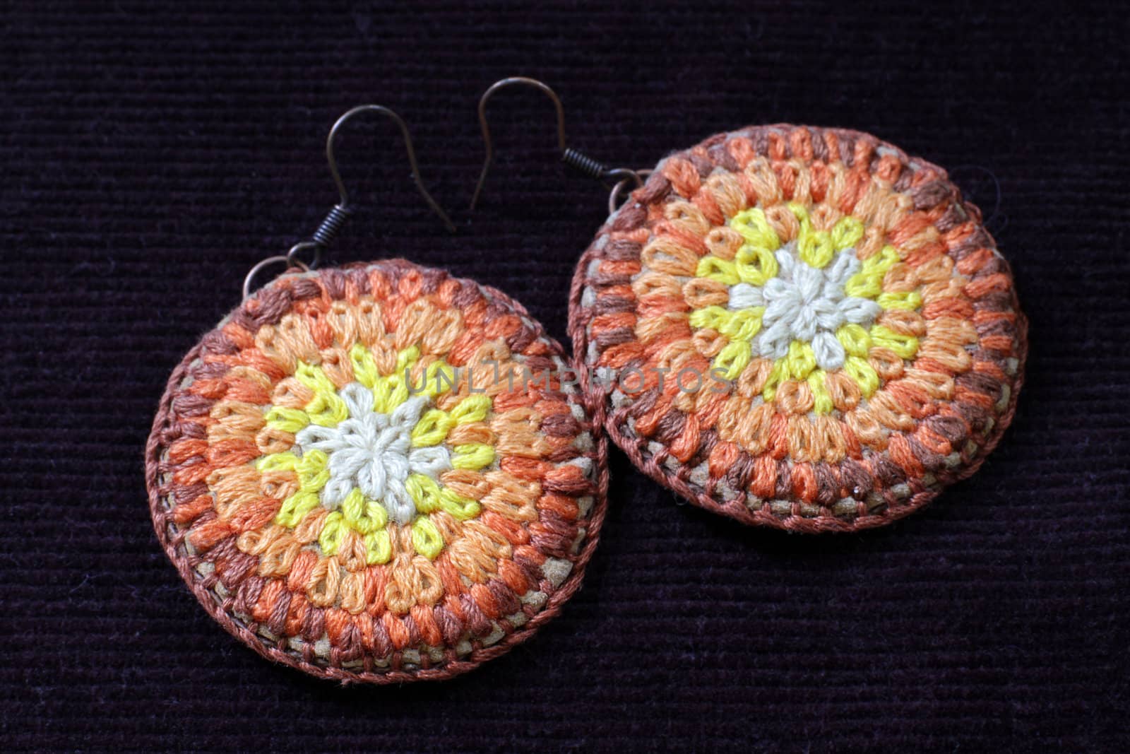 Knitted earrings on a velvet background. Handmade.