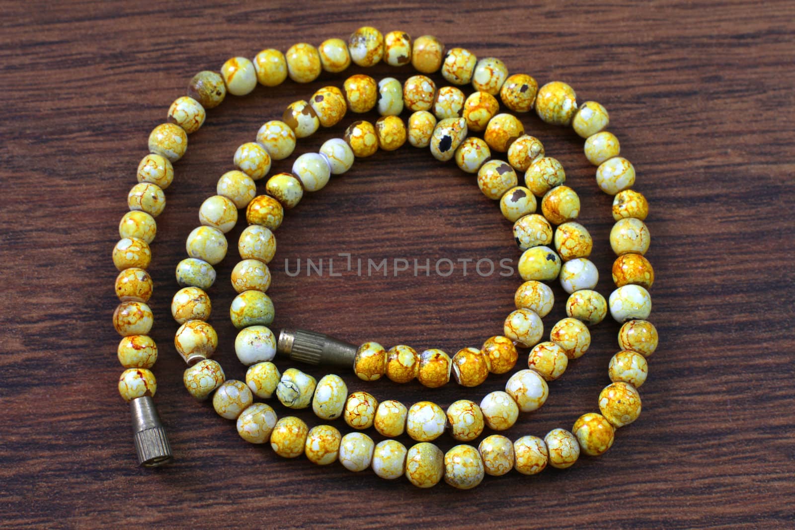 yellow plastic beads on brown background