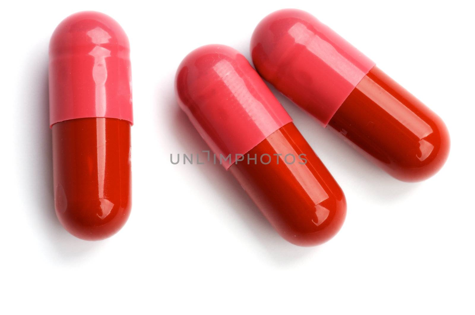 Three Red and Pink Pill Capsules isolated on white background. Top View