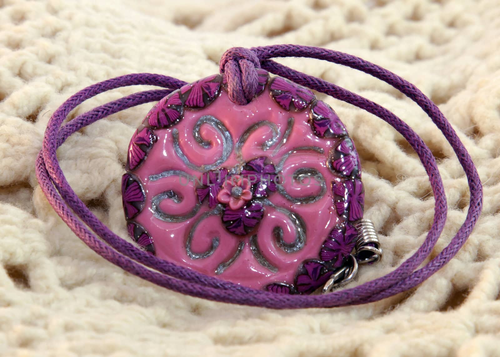 clay handmade red and violet flower on a knitted background