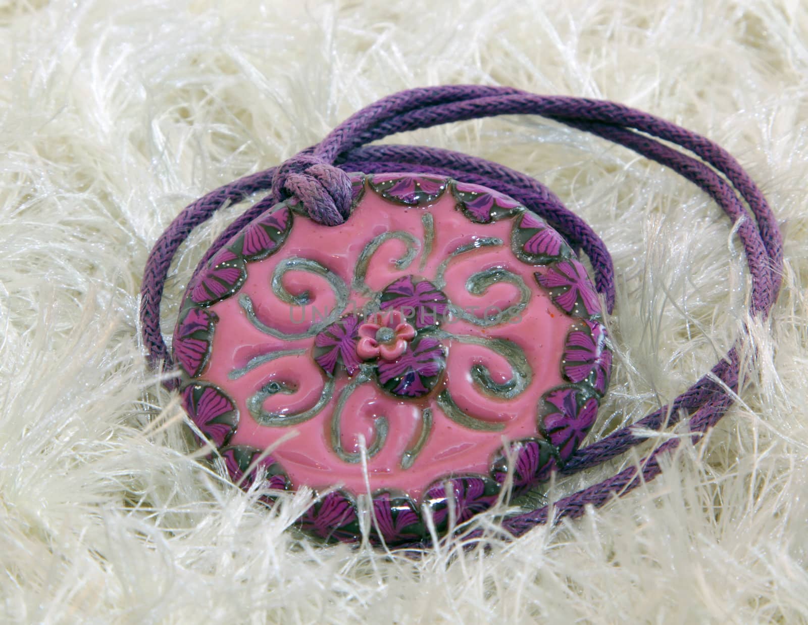 clay handmade red and violet flower on a knitted background