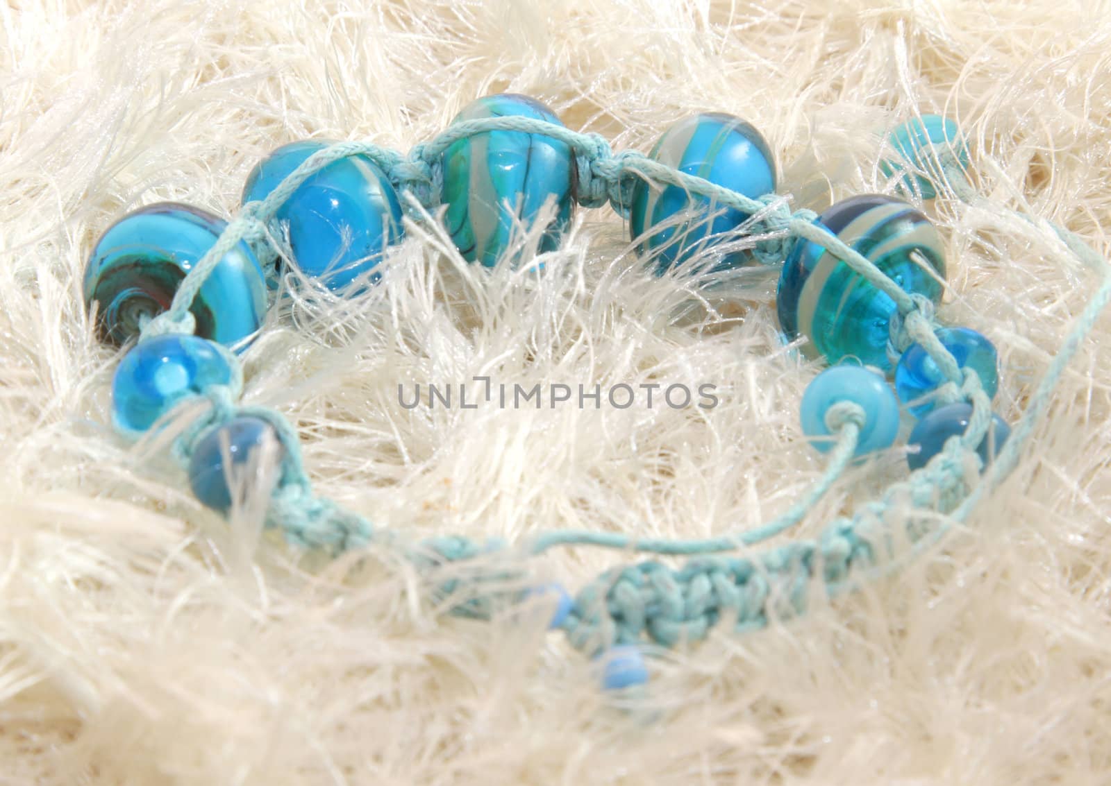 Blue beaded bracelet on the pale knitted background