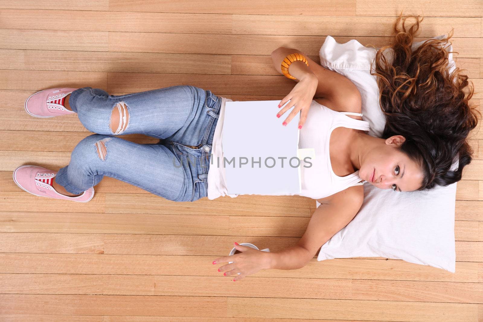 A young adult woman sleeping after reading a book.