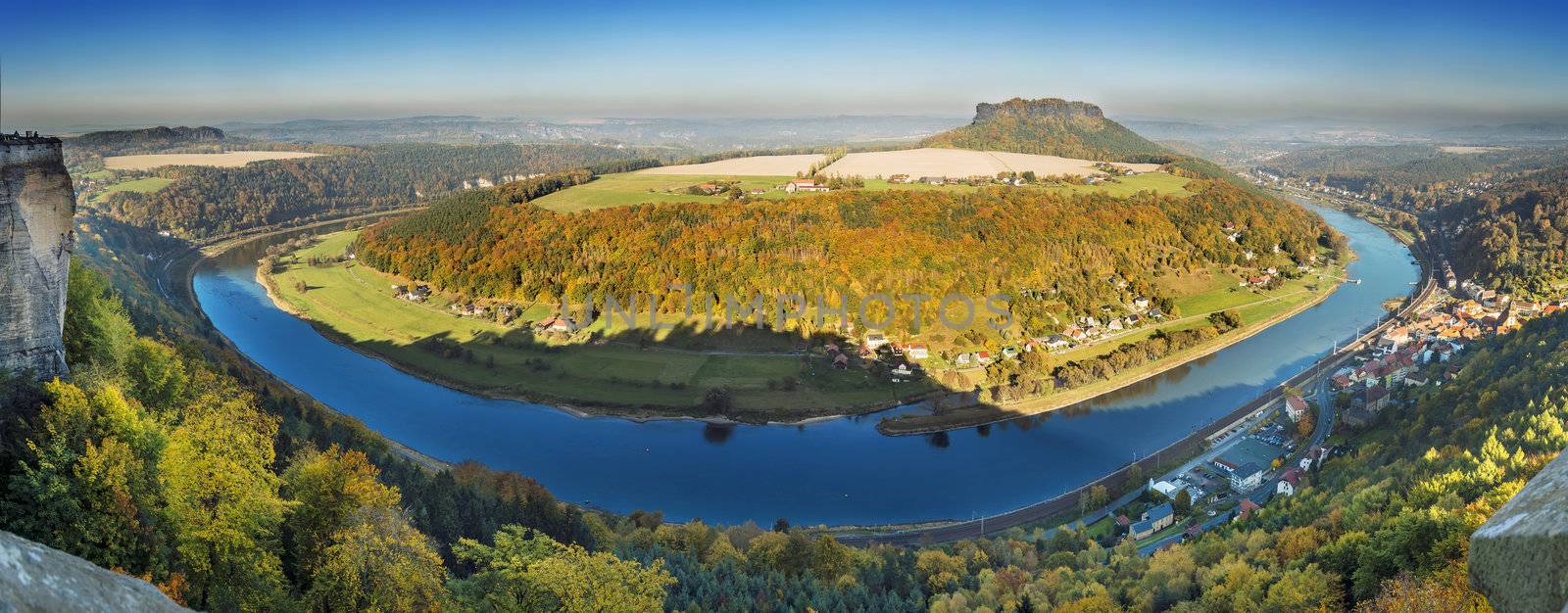 Panoramic shot of a landscape in autumn in Saxon Switzerland, overlooking the Elbe, villages, houses and the mountain named Lily Stone
