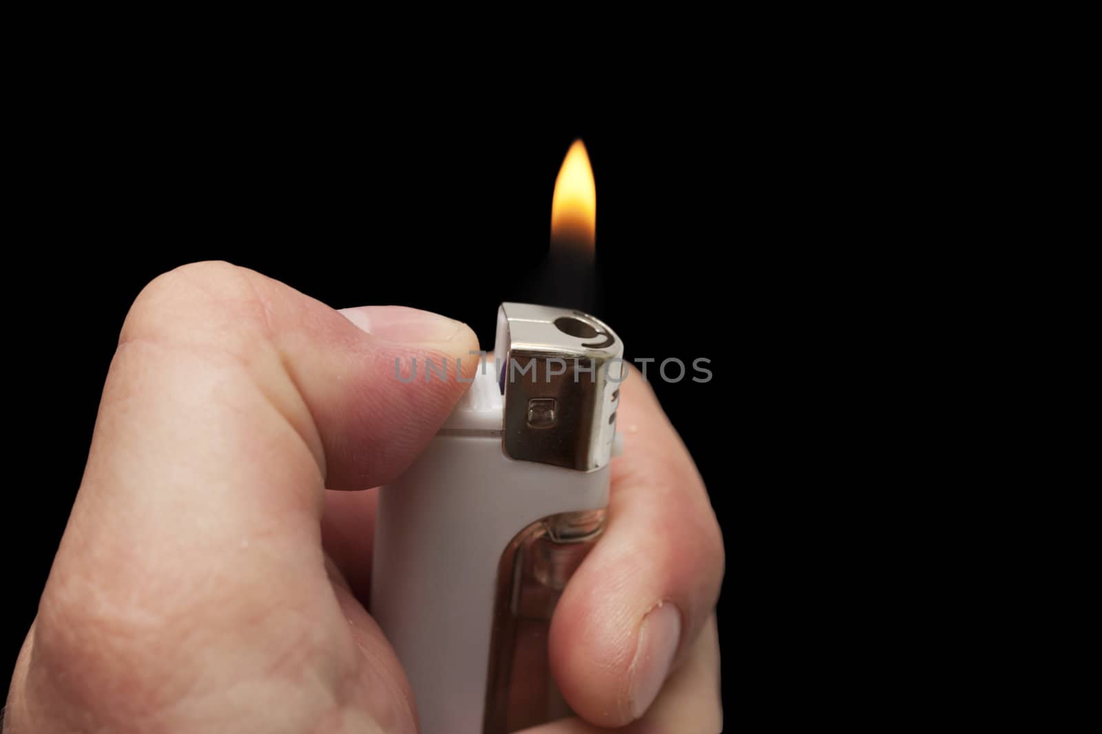 hand with a cigarette lighter on a black background