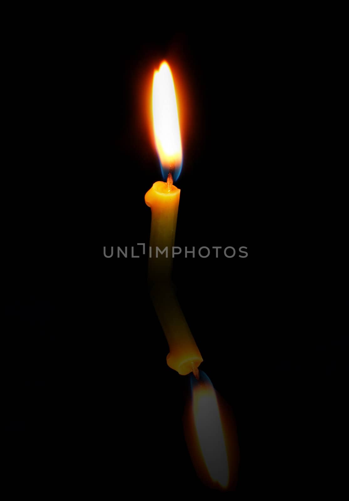 Church Candle with a reflection on a black background