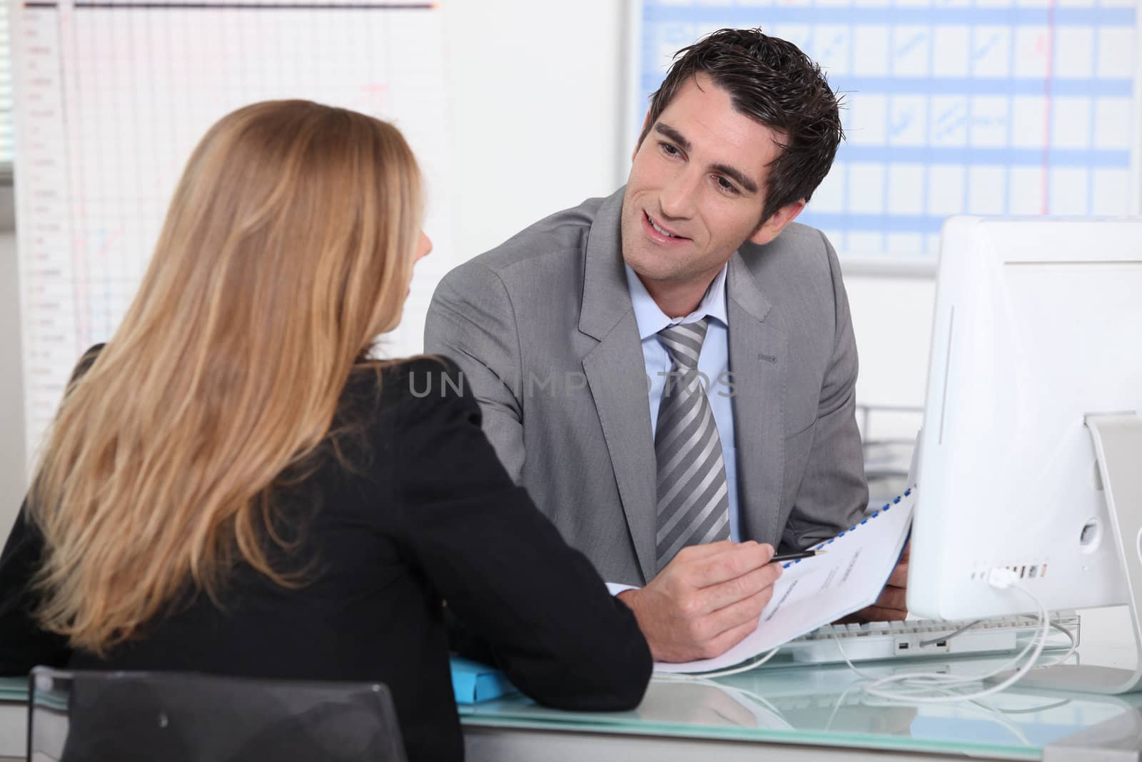 Man interviewing a young woman across a desk