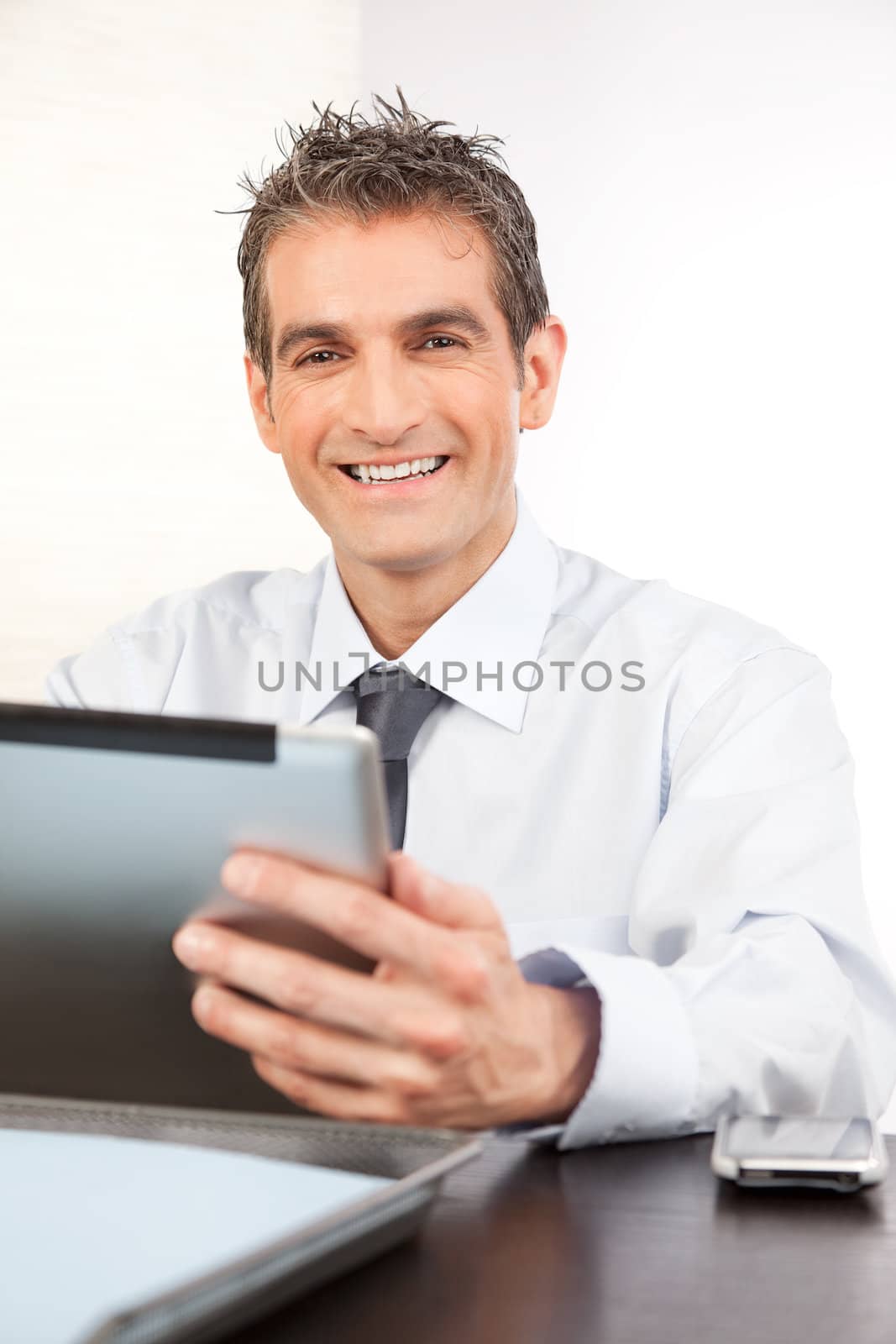 Businessman holding digital tablet at work isolated on white background.