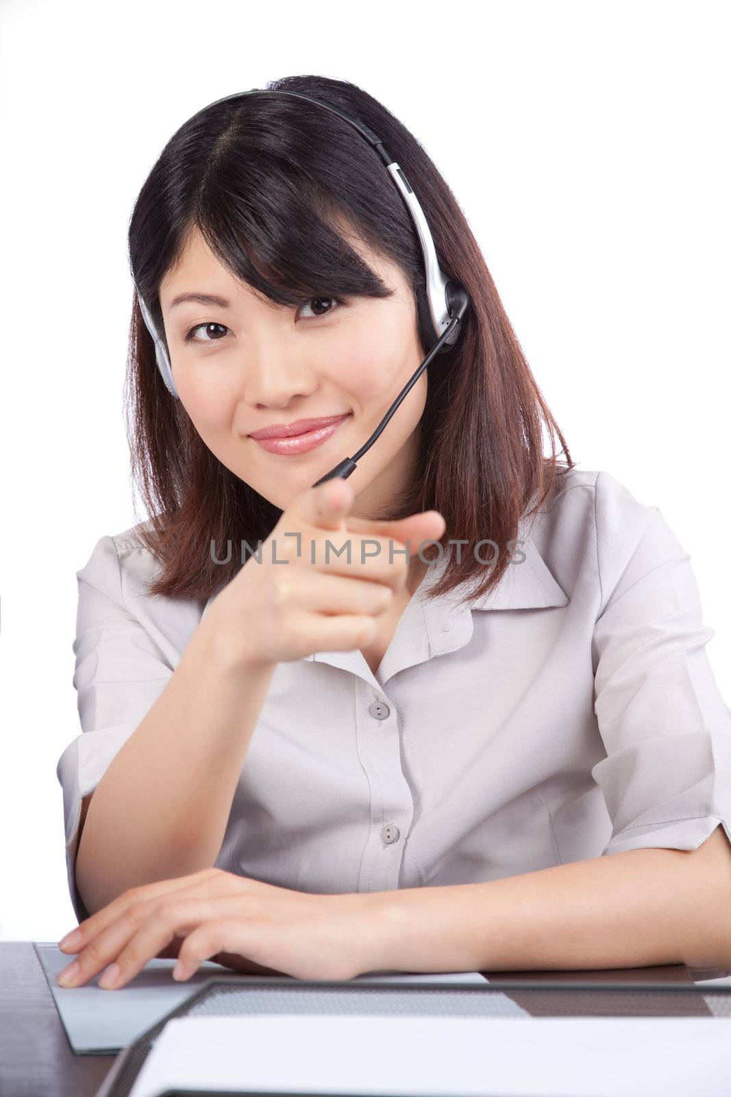 Businesswoman wearing a headset pointing finger isolated on white background.