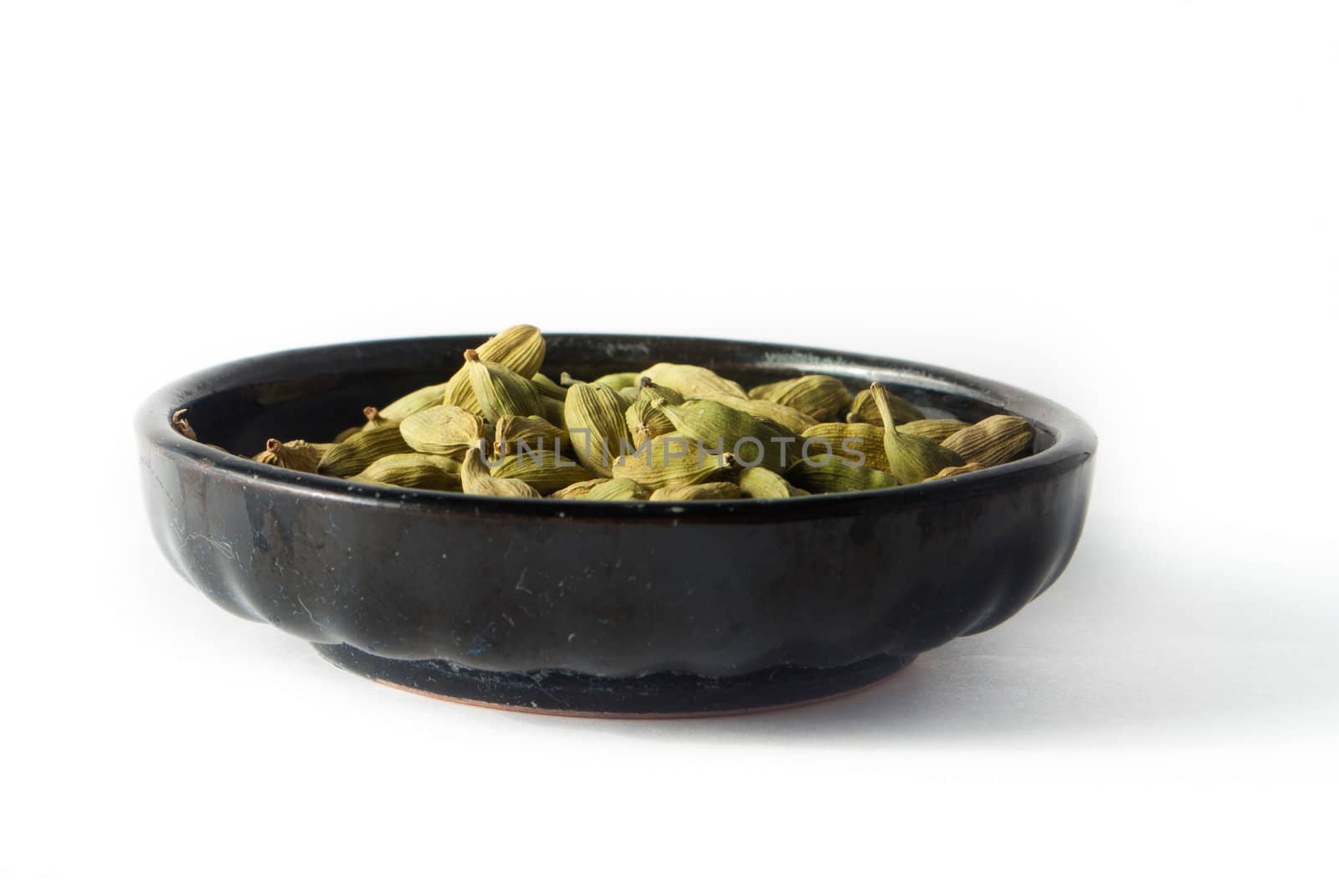 Pile of whole cardamom on white background