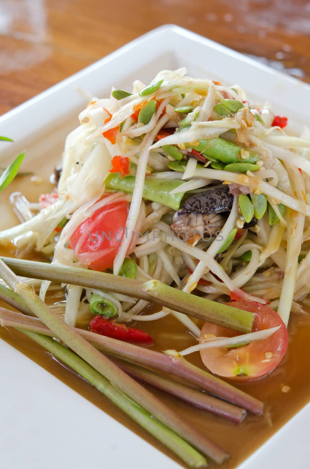 close up of spicy papaya salad  on white dish