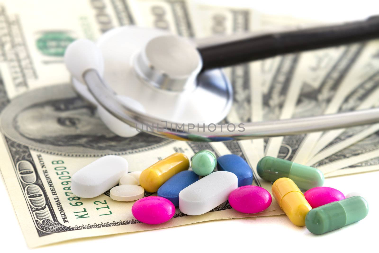 Pills, money and stethoscope on white background