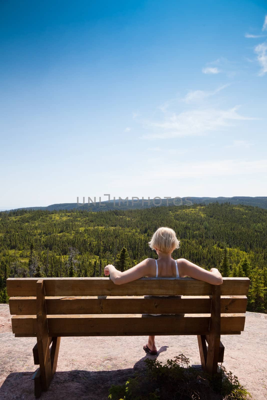 Girl sitting on a bench and looking to the amazing panorama !