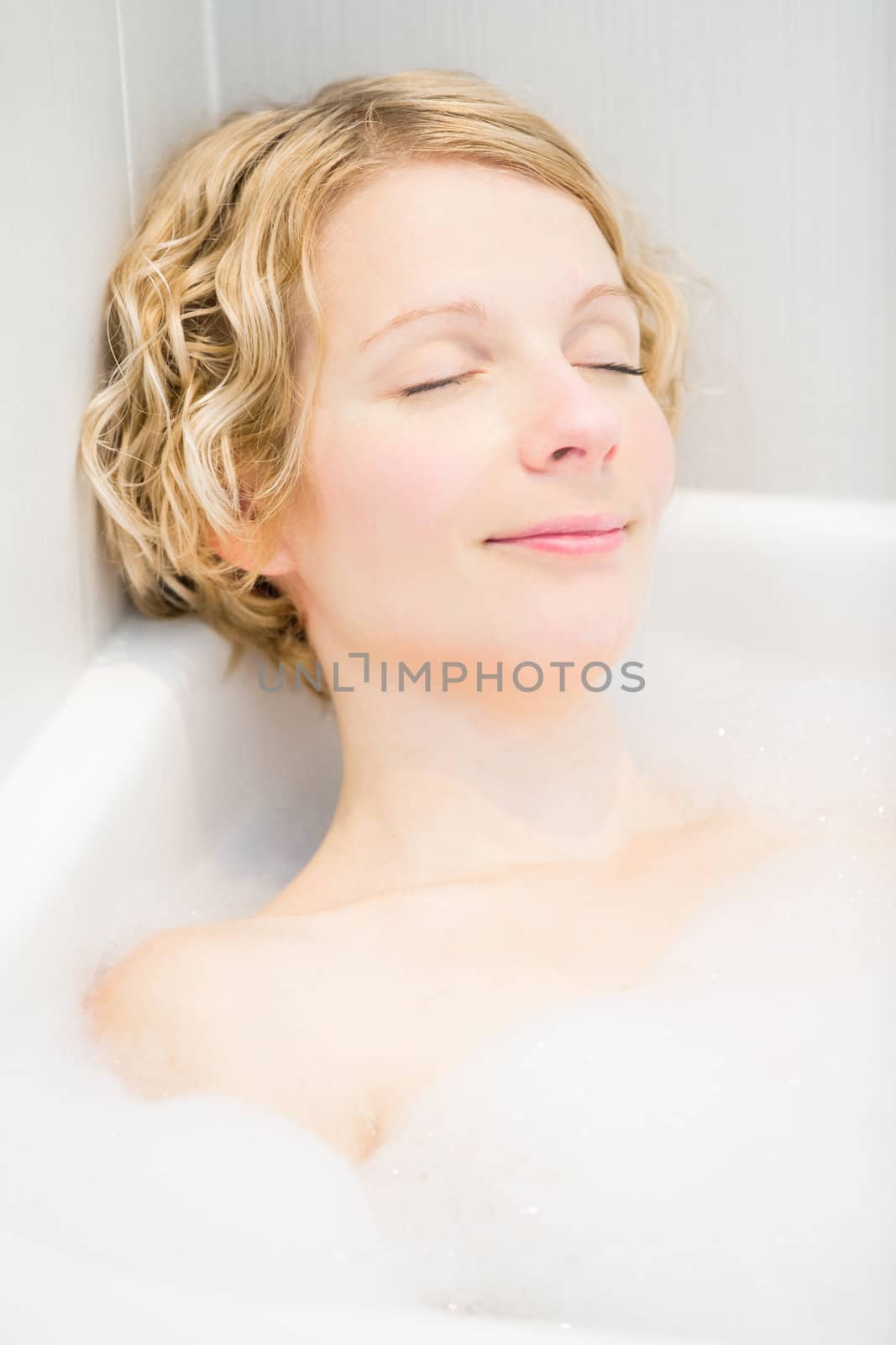 Happy young woman relaxing in the bath