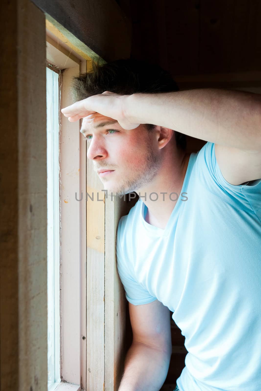 Young man at the window watching outside