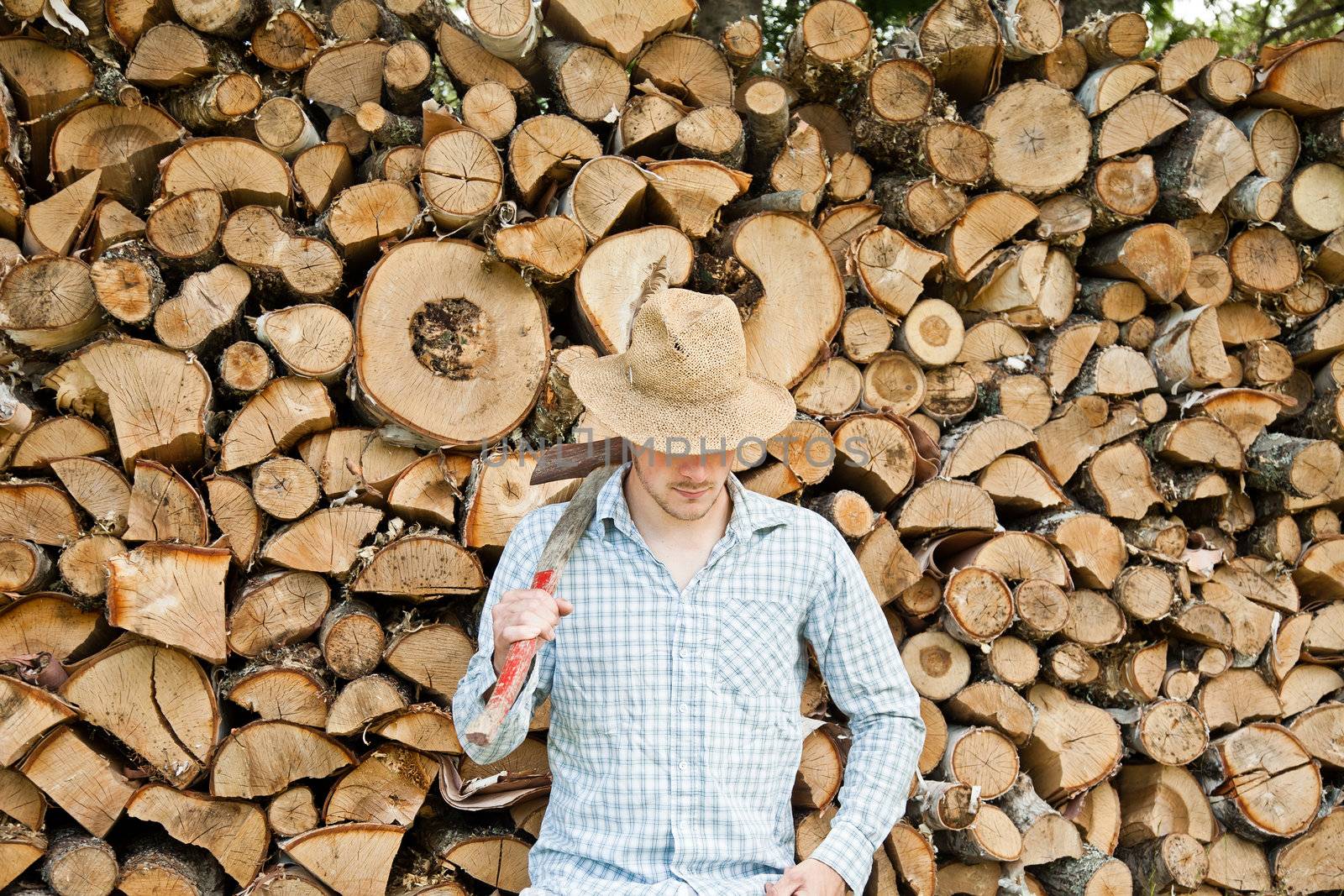 Woodcutter with straw hat on a background of wood by aetb