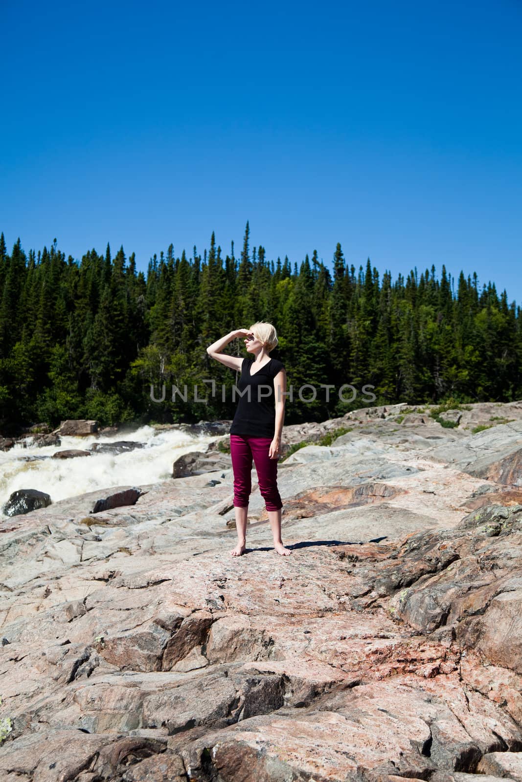 Young girl on a rock in the middle of the nature.