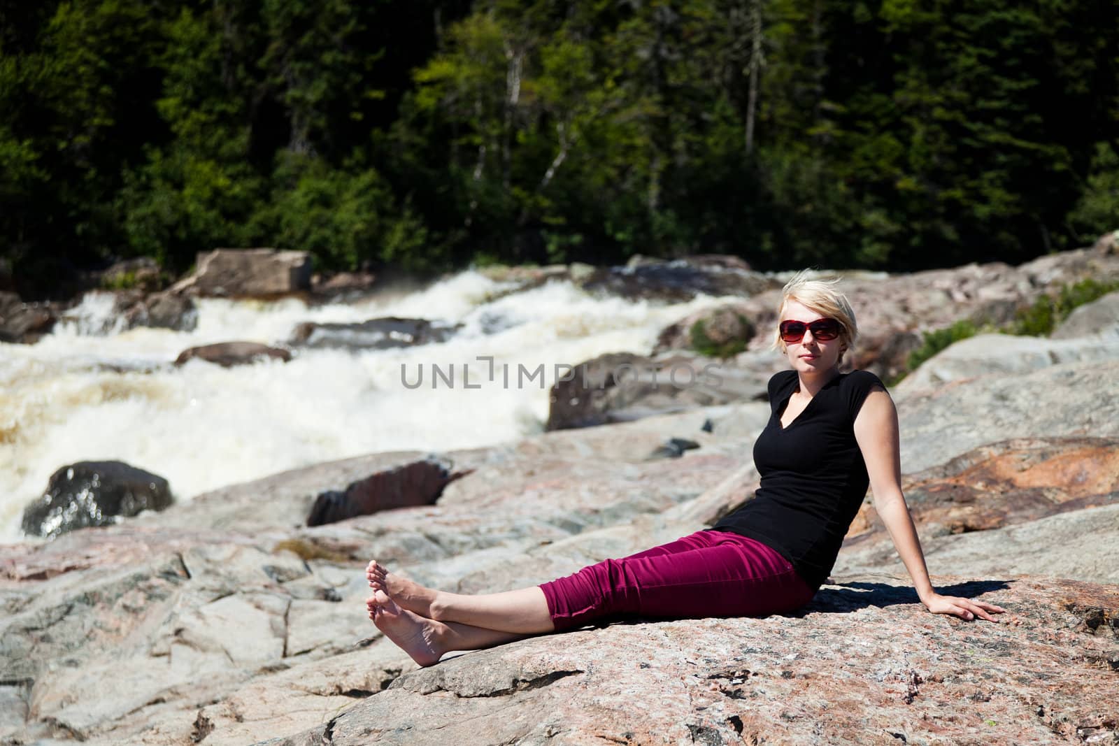 Young girl sitting on a rock and relaxing by aetb