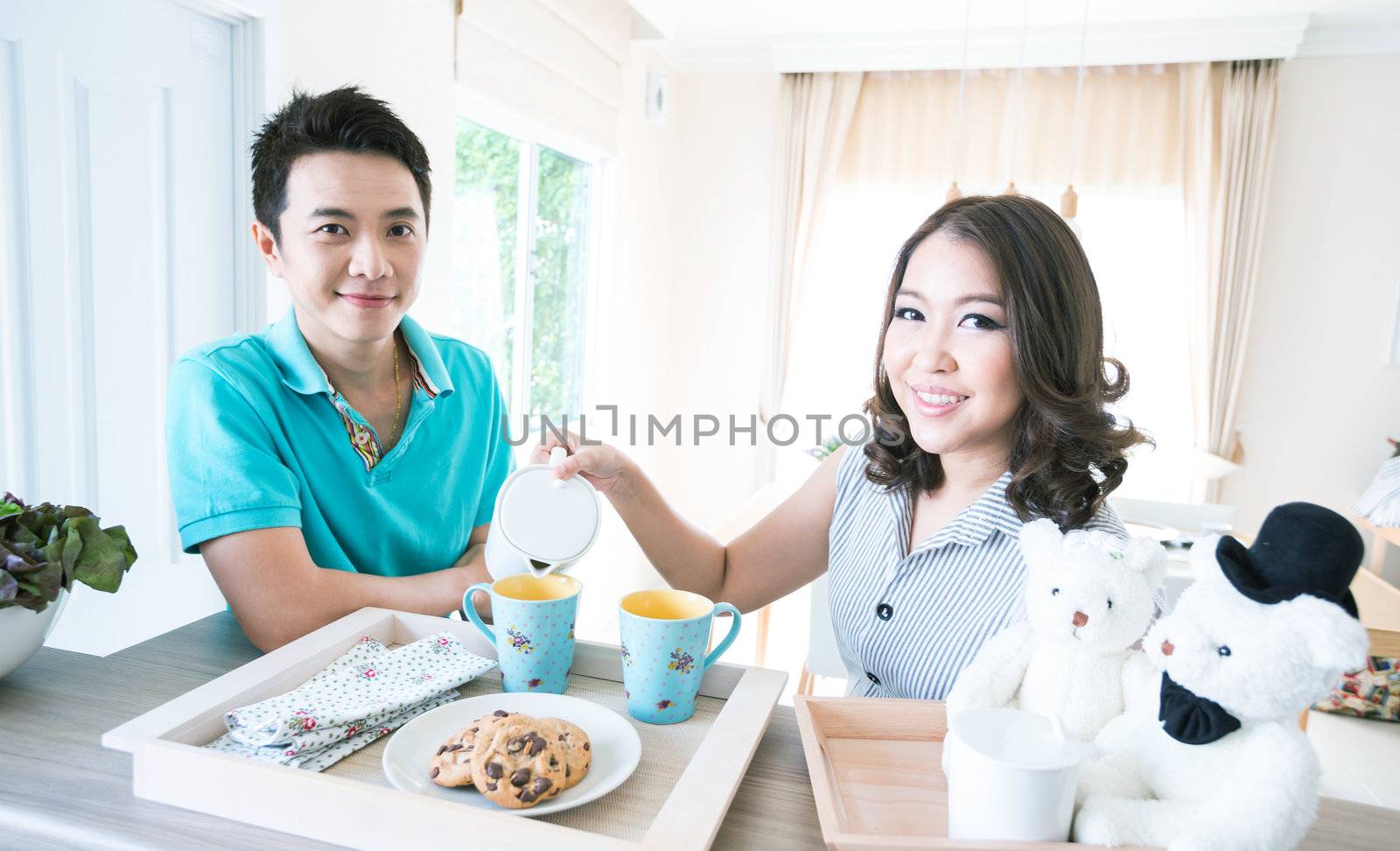 Young happy couples in domestic kitchen with breakfast