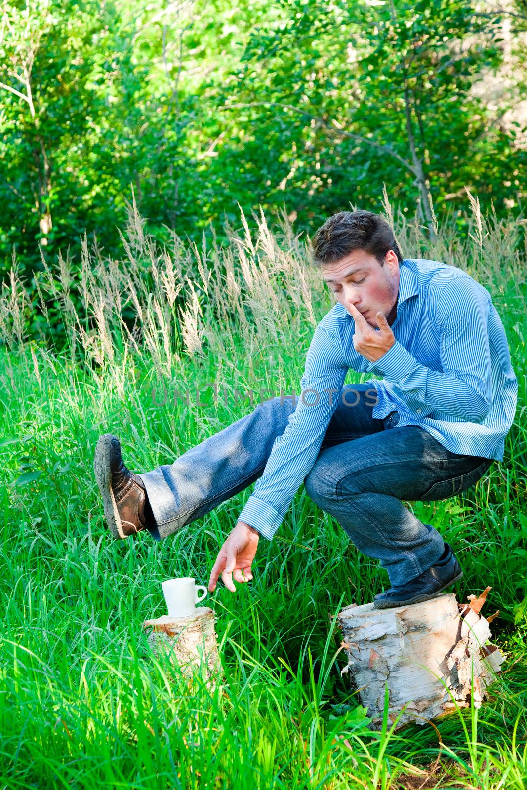 Young businessman in nature doing acrobatic poses